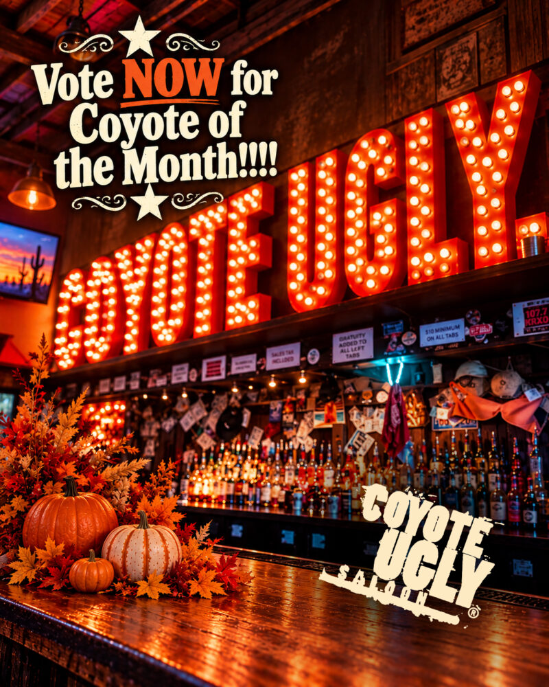 Coyote Ugly bar decorated with autumn leaves and pumpkins, featuring a glowing “COYOTE UGLY” sign and “Vote NOW for Coyote of the Month!!!!” text.